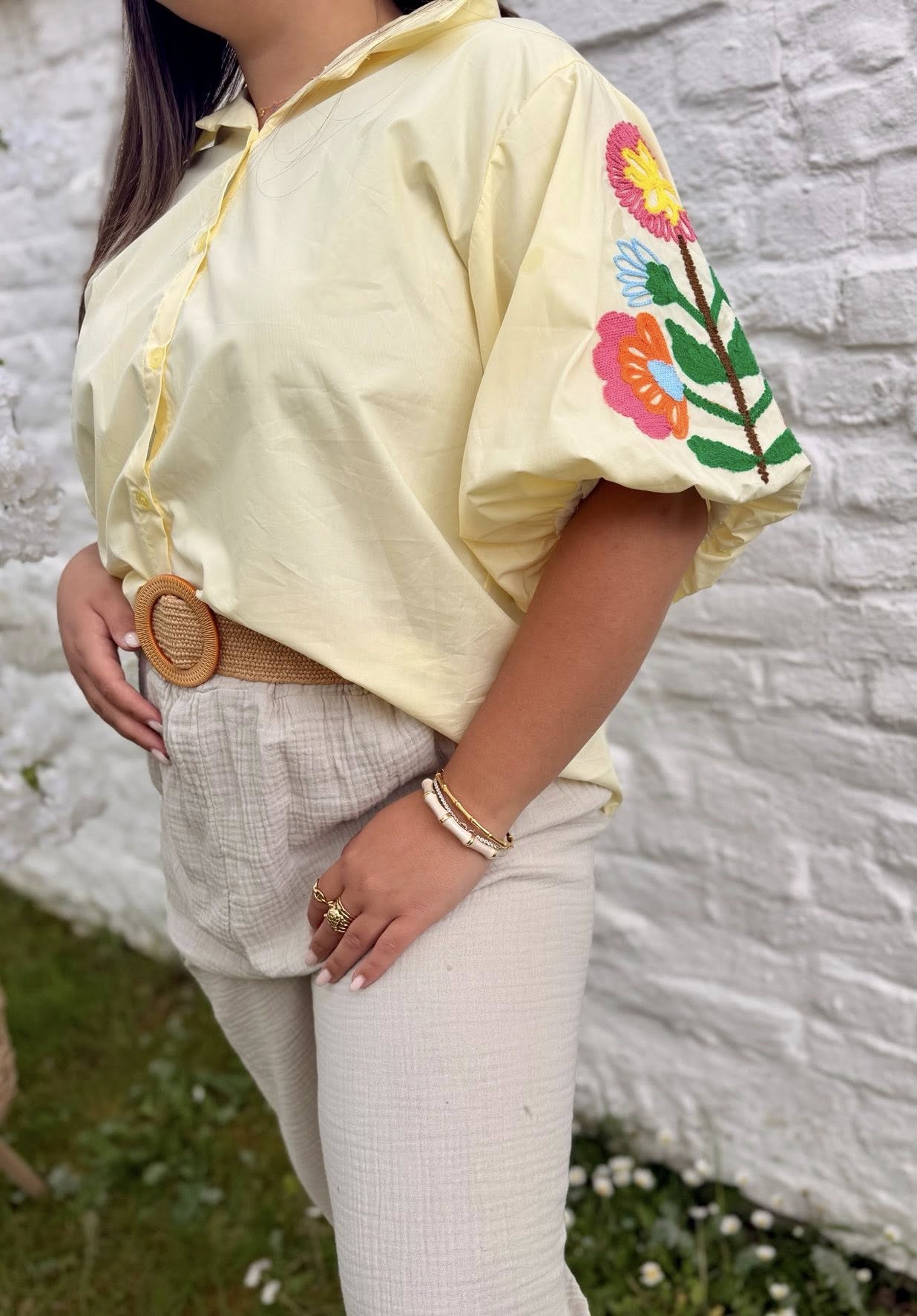 Chemise jaune pâle aux manches ballon et motifs fleuris.